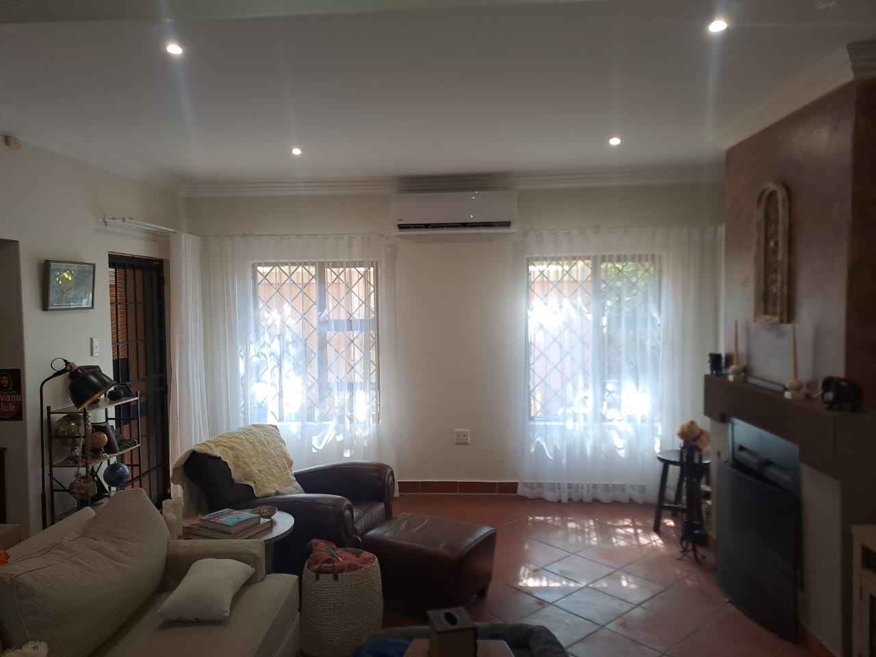 Residential living room with wall-mounted split unit air conditioner installed above windows